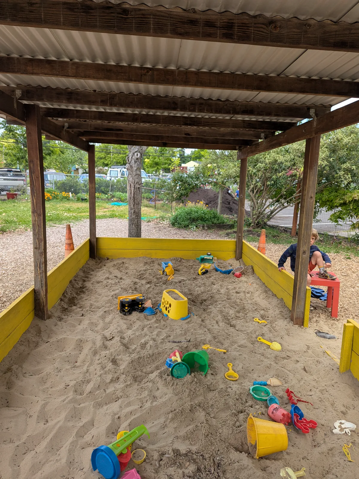 Inside the painted yellow sandbox with children playing