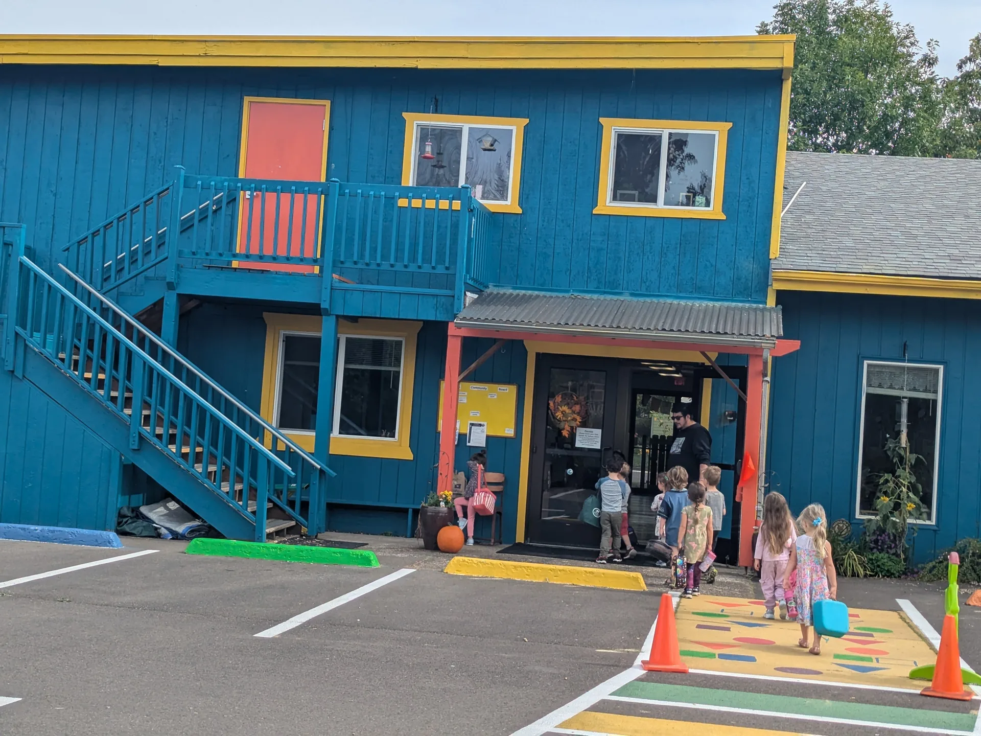 Colorful blue school building with children walking to the front entrance